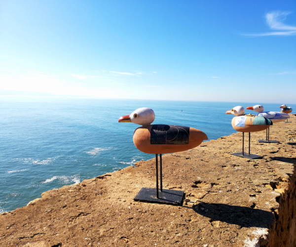 Vista do mar com estátua de pequenas gaivotas